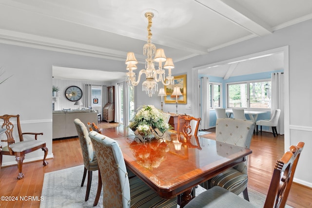 dining space with an inviting chandelier, beamed ceiling, light hardwood / wood-style flooring, and ornamental molding