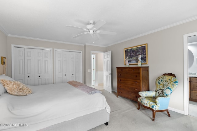 bedroom with crown molding, ceiling fan, multiple closets, and light colored carpet