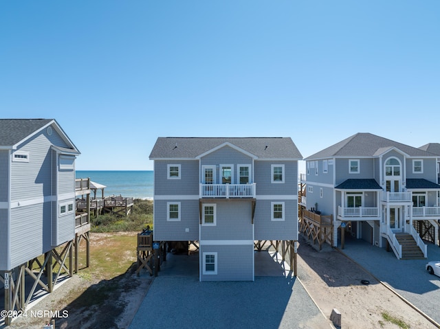 back of property featuring a water view, a carport, and a balcony