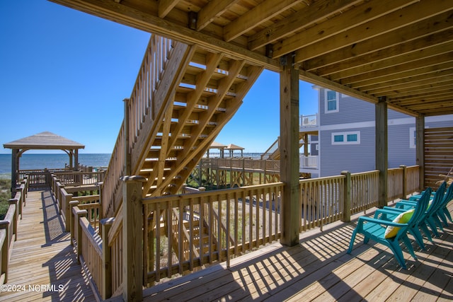 wooden terrace with a water view and a gazebo