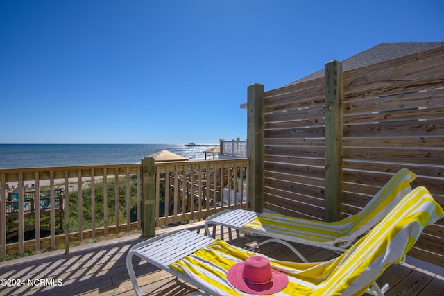 deck featuring a view of the beach and a water view