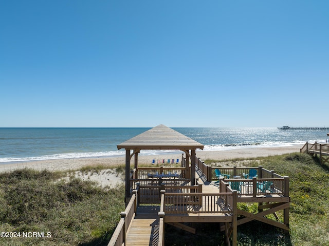 view of home's community featuring a view of the beach, a gazebo, and a deck with water view