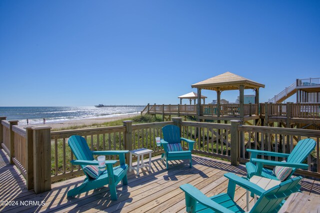 deck featuring a beach view, a gazebo, and a water view