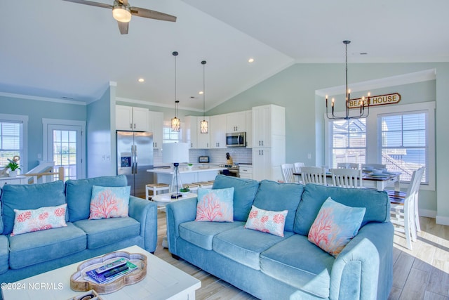 living room with lofted ceiling, crown molding, a wealth of natural light, and light wood-type flooring