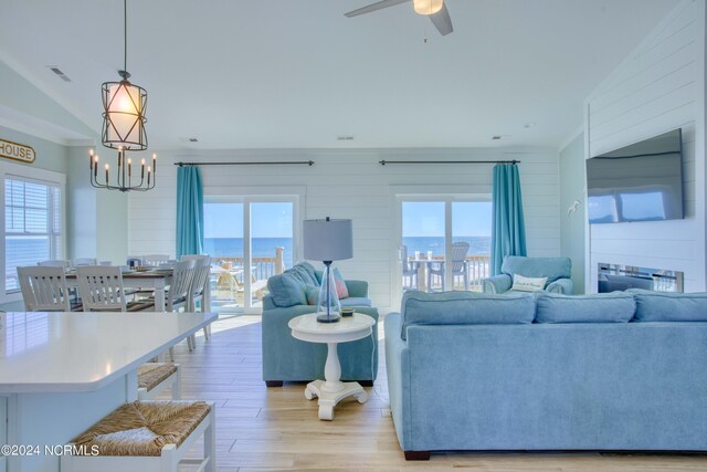 1016 New River Inlet Rd, North Topsail Beach, NC 28460 - living area with visible vents, crown molding, ceiling fan with notable chandelier, wood walls, and light wood-style flooring