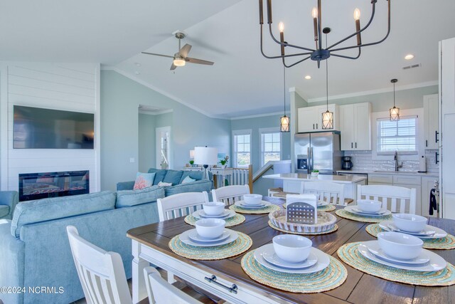 1016 New River Inlet Rd, North Topsail Beach, NC 28460 - dining room featuring a healthy amount of sunlight, ceiling fan with notable chandelier, lofted ceiling, and visible vents