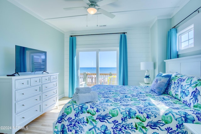 bedroom featuring ceiling fan, wooden walls, and light hardwood / wood-style flooring