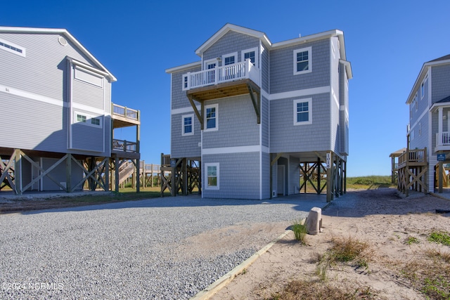 back of house with a balcony and a carport