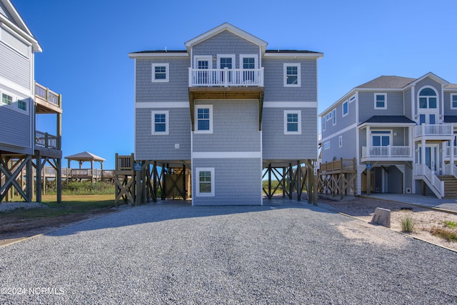 rear view of property with a balcony and a carport