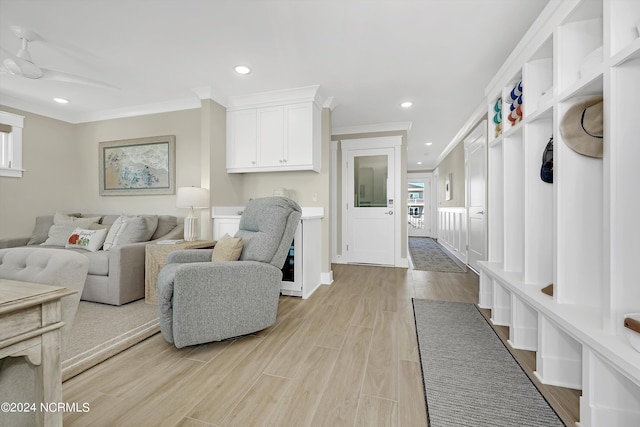 living room with crown molding and light hardwood / wood-style flooring