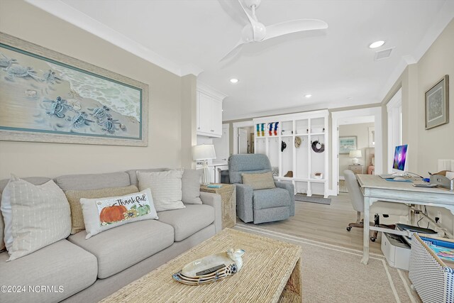 living room featuring crown molding, light wood-type flooring, and ceiling fan