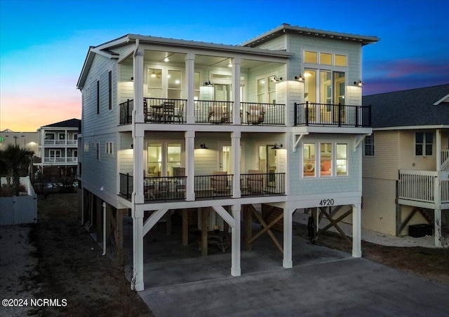 back house at dusk with a balcony