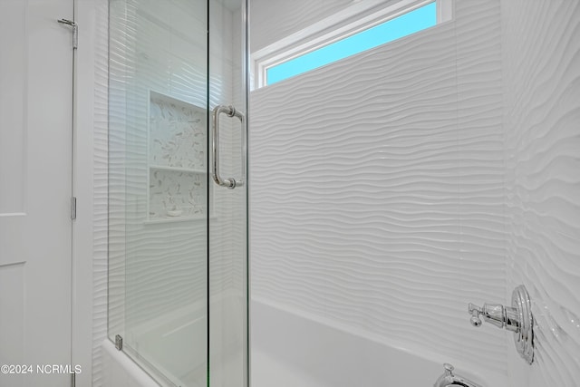 bathroom featuring bath / shower combo with glass door