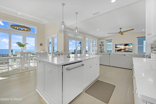 kitchen featuring white cabinets, a center island with sink, dishwasher, sink, and a water view