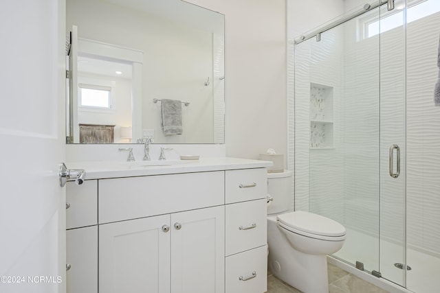 bathroom featuring vanity, walk in shower, toilet, and tile patterned flooring