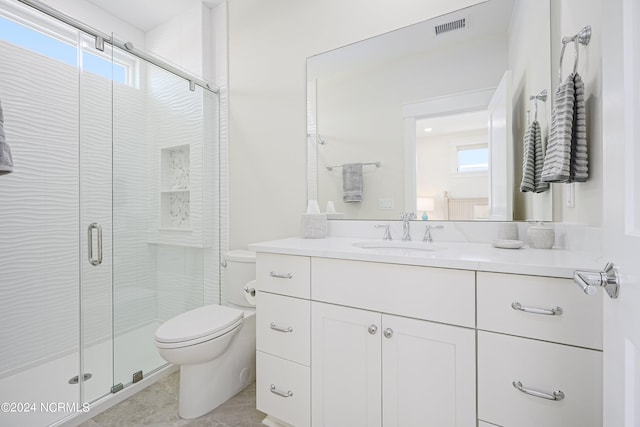 bathroom with vanity, a shower with shower door, toilet, and tile patterned flooring