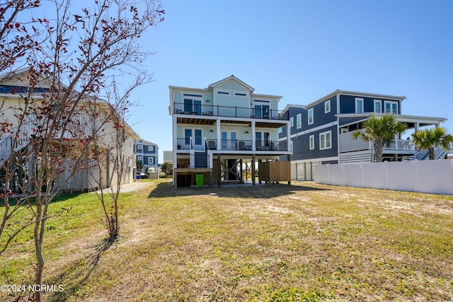 back of house with a yard and a balcony