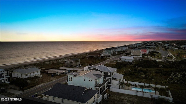 aerial view at dusk featuring a water view