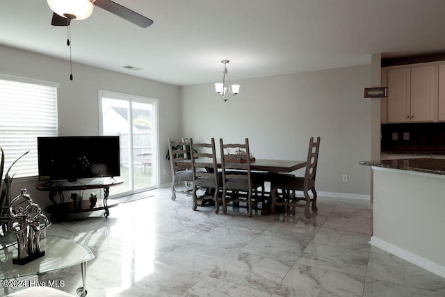 dining space with ceiling fan with notable chandelier