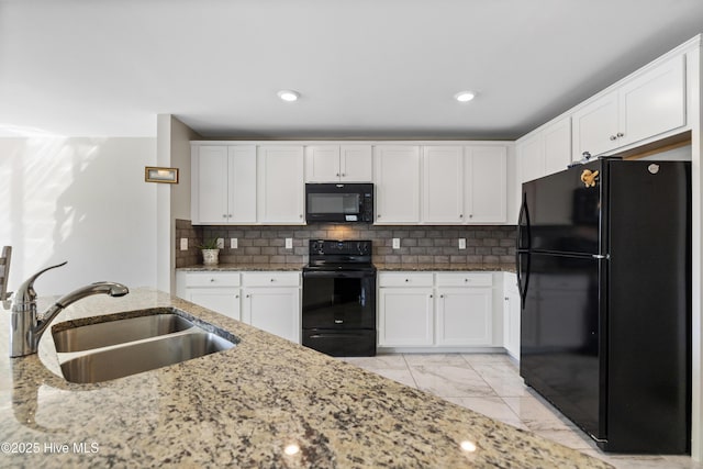 kitchen with light stone counters, marble finish floor, white cabinetry, a sink, and black appliances