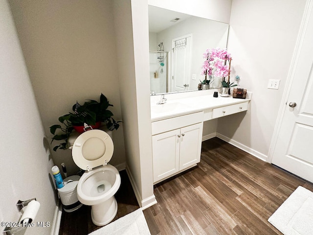 bathroom featuring toilet, a shower, vanity, and wood-type flooring