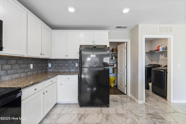 kitchen featuring visible vents, white cabinets, dark stone countertops, and freestanding refrigerator