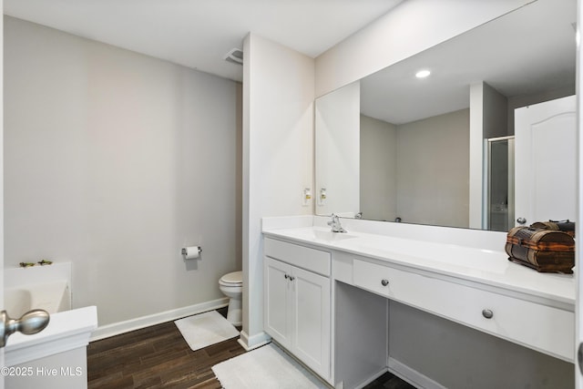 full bathroom with visible vents, baseboards, wood finished floors, a garden tub, and vanity