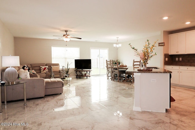 living room with ceiling fan with notable chandelier