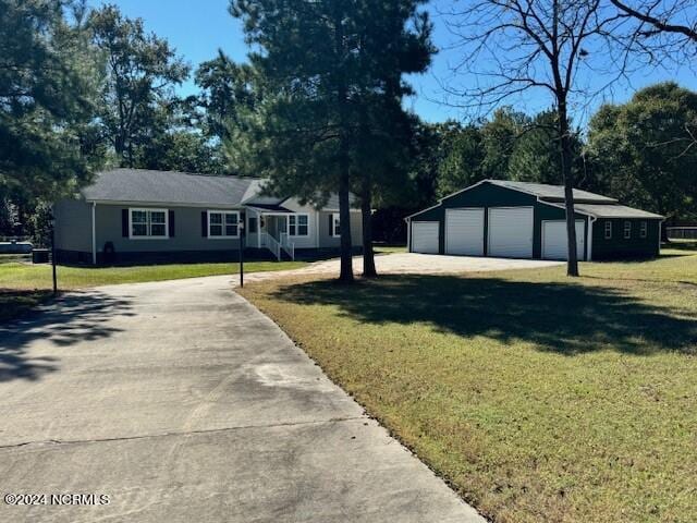 view of front of house featuring a garage, a front yard, and an outdoor structure