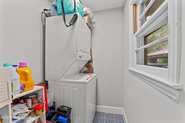 clothes washing area with stacked washing maching and dryer