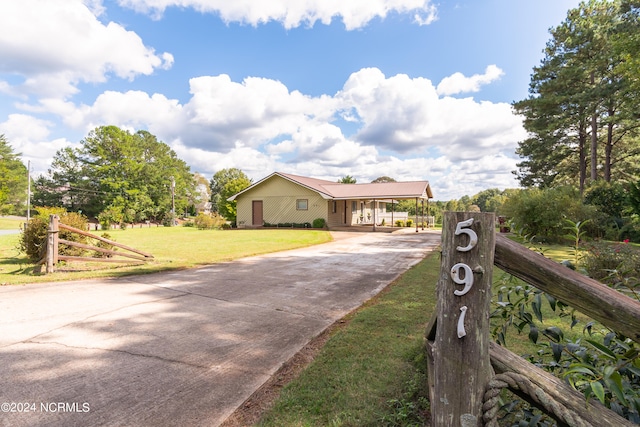 view of front of property with a carport and a front yard