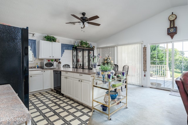 kitchen with lofted ceiling, black appliances, ceiling fan, light carpet, and white cabinetry