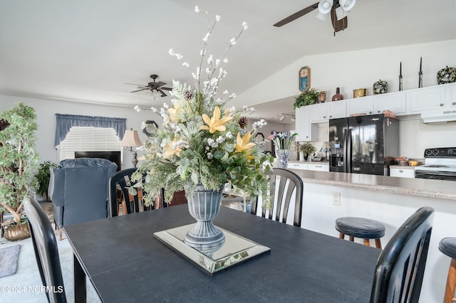 dining space featuring ceiling fan and vaulted ceiling