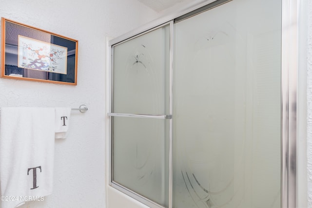 bathroom with bath / shower combo with glass door