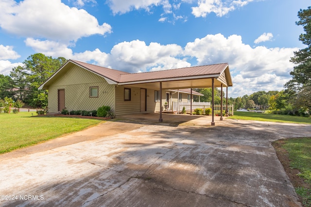 view of front of property with a front yard and a carport