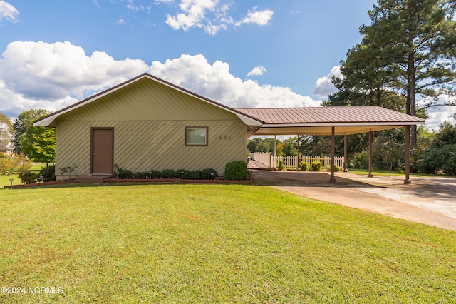 view of side of home featuring a carport and a yard