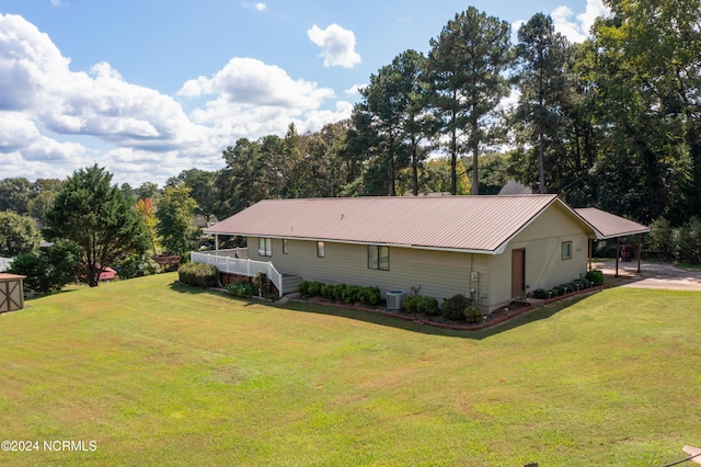 back of property with cooling unit, a yard, and a deck