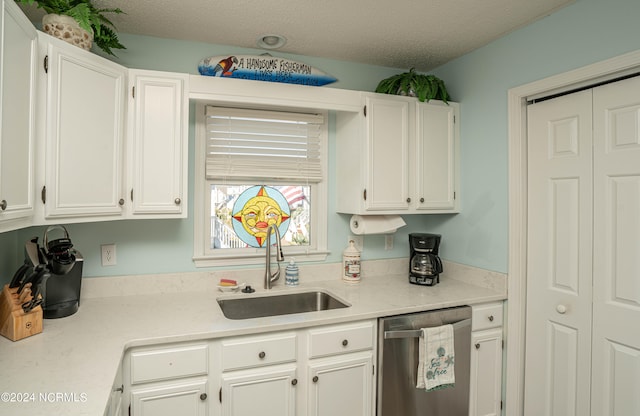 kitchen featuring dishwasher, white cabinets, sink, and a textured ceiling