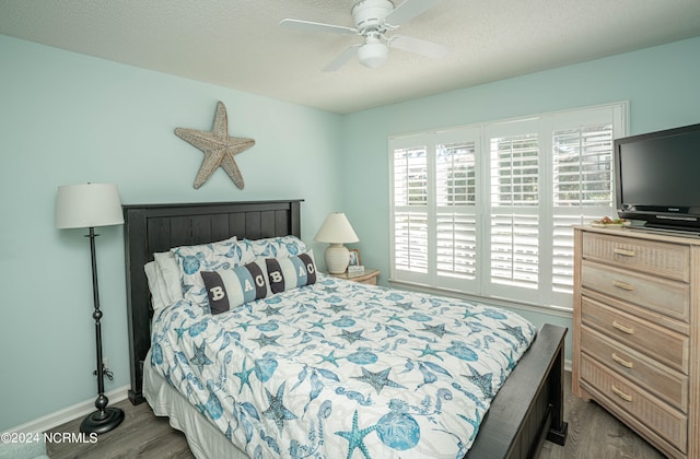 bedroom with multiple windows, a textured ceiling, hardwood / wood-style flooring, and ceiling fan