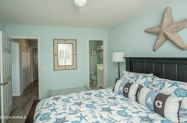 bedroom with ensuite bathroom, a textured ceiling, a closet, ceiling fan, and hardwood / wood-style flooring