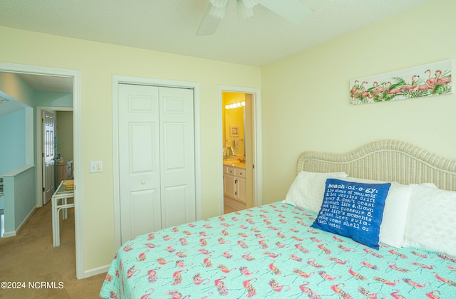 carpeted bedroom with a closet, ensuite bath, and ceiling fan