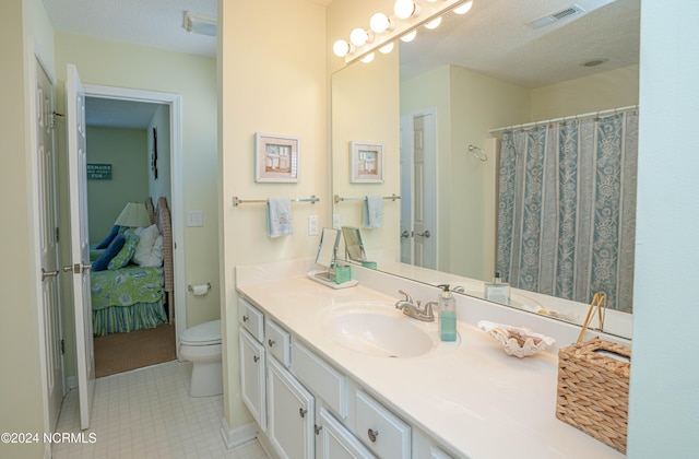 bathroom with vanity, a textured ceiling, and toilet