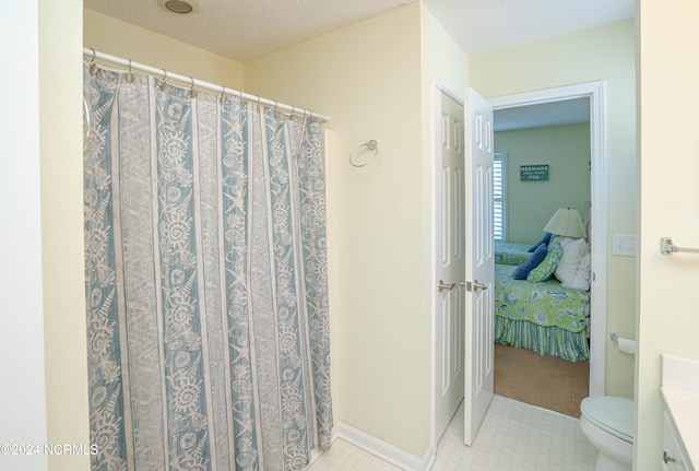 bathroom featuring vanity, a textured ceiling, curtained shower, and toilet