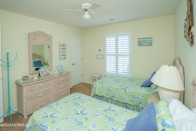 carpeted bedroom featuring a textured ceiling and ceiling fan