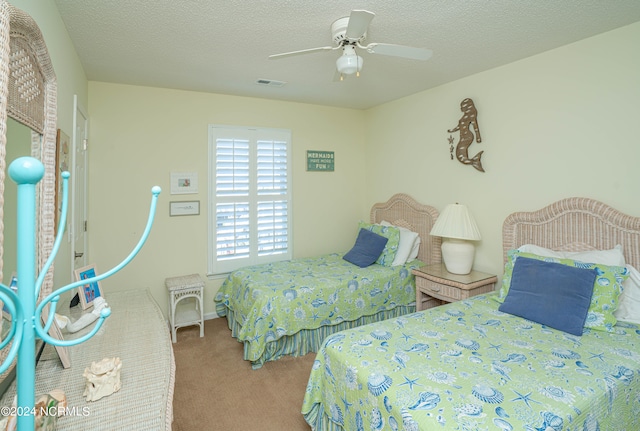 bedroom featuring a textured ceiling, carpet floors, and ceiling fan