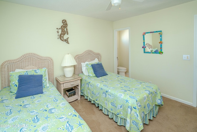 carpeted bedroom with ceiling fan and ensuite bath