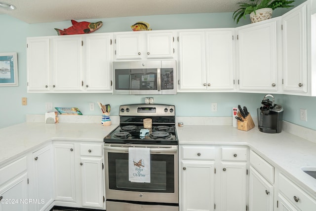 kitchen featuring a textured ceiling, white cabinets, and stainless steel appliances