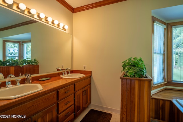 bathroom with tile patterned flooring, ornamental molding, vanity, and a healthy amount of sunlight