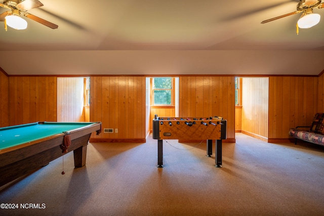 recreation room with ceiling fan and wood walls