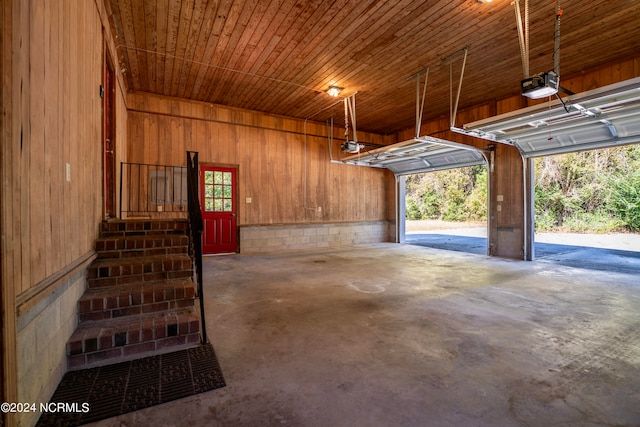 garage featuring a garage door opener, wooden walls, and wooden ceiling